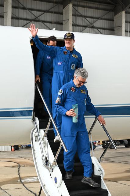 Artemis II Mission Specialist Jeremy Hansen (center) returns...