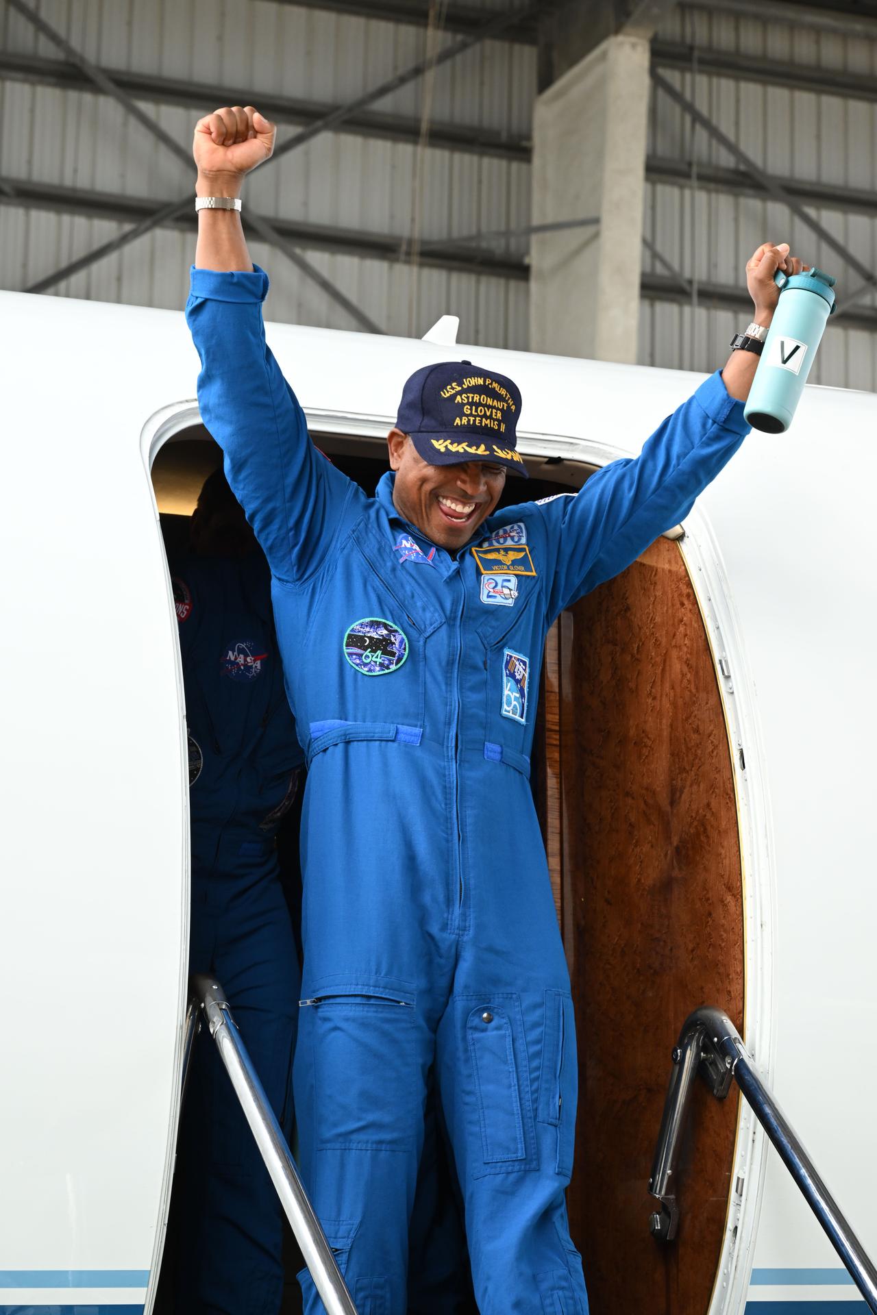 jsc2026e022275 (April 11, 2026) - Artemis II Pilot Victor Glover returns home to Houston, stepping off a plane at Ellington Airport near NASA's Johnson Space Center, on Saturday, April 11, 2026, following his 10-day mission around the Moon. He and his three fellow crew members launched April 1, 2026, from NASA’s Kennedy Space Center in Florida, and splashed down off the coast of California on Friday, April 10, 2026.