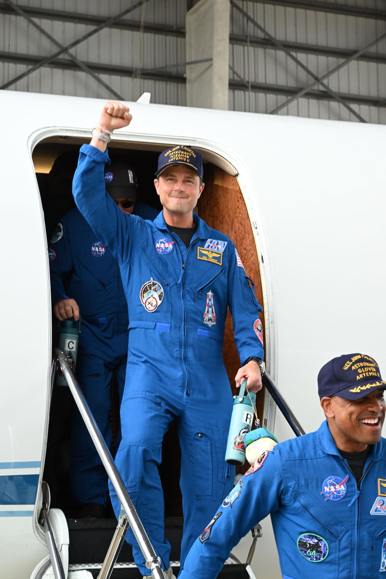 jsc2026e022276 (April 11, 2026) - Artemis II Commander Reid Wiseman returns home to Houston, stepping off a plane at Ellington...