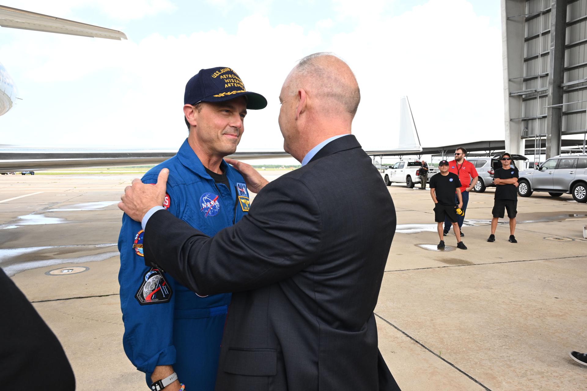 jsc2026e022283 (April 11, 2026) - Commander Reid Wiseman is greeted by NASA's Flight Operations Director Norm Knight on his return home to Houston, at Ellington Airport on Saturday, April 11, 2026, following a 10-day trip around the Moon and back. Wiseman and his three fellow crew members launched April 1, 2026, from NASA’s Kennedy Space Center in Florida, and splashed down off the coast of California on Friday, April 10, 2026.