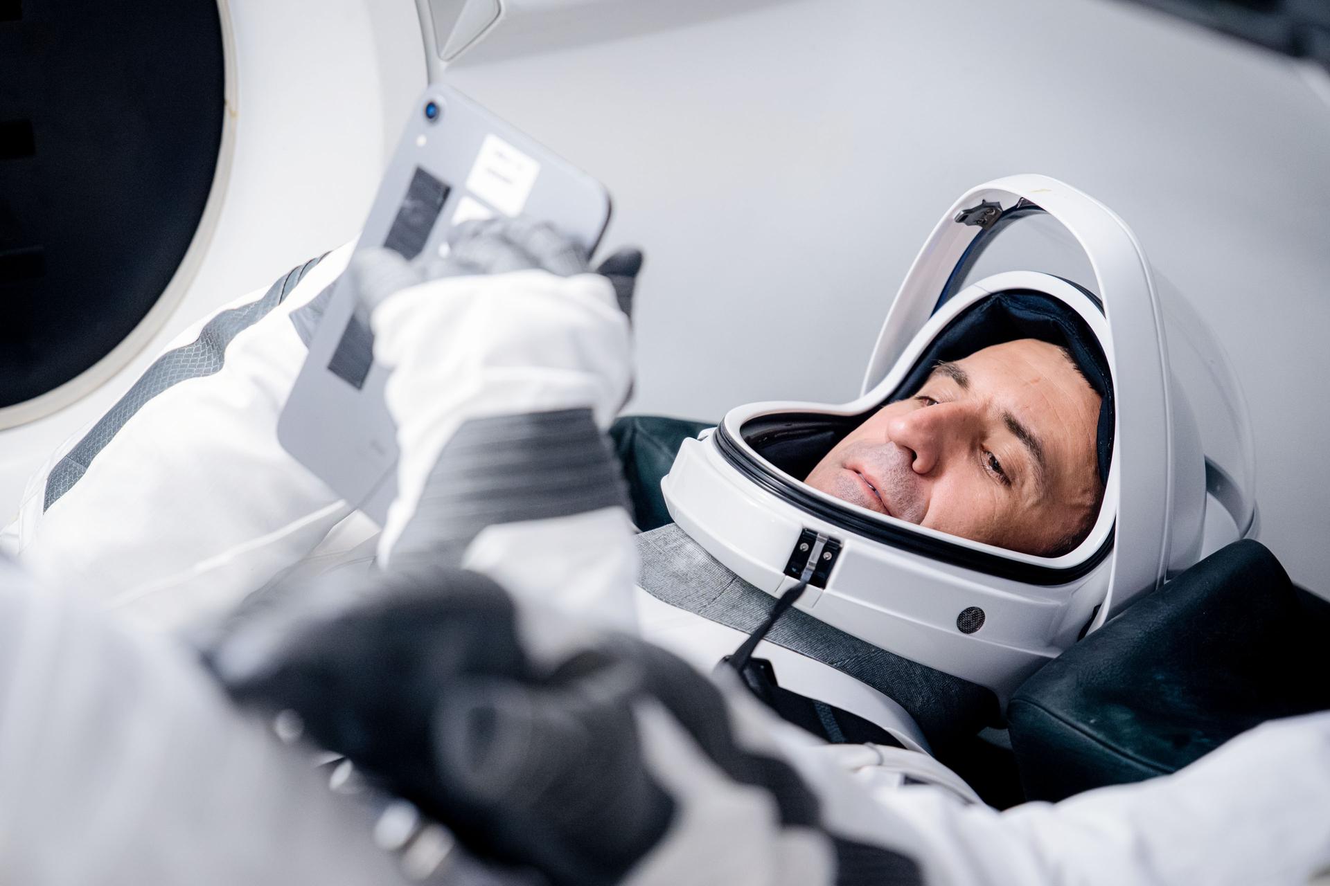 Roscosmos cosmonaut and SpaceX Crew-13 Mission Specialist Sergey Teteryatnikov is pictured in his pressure suit and seated inside a SpaceX Dragon spaceraft during a training session at SpaceX headquarters in Hawthorne, California.