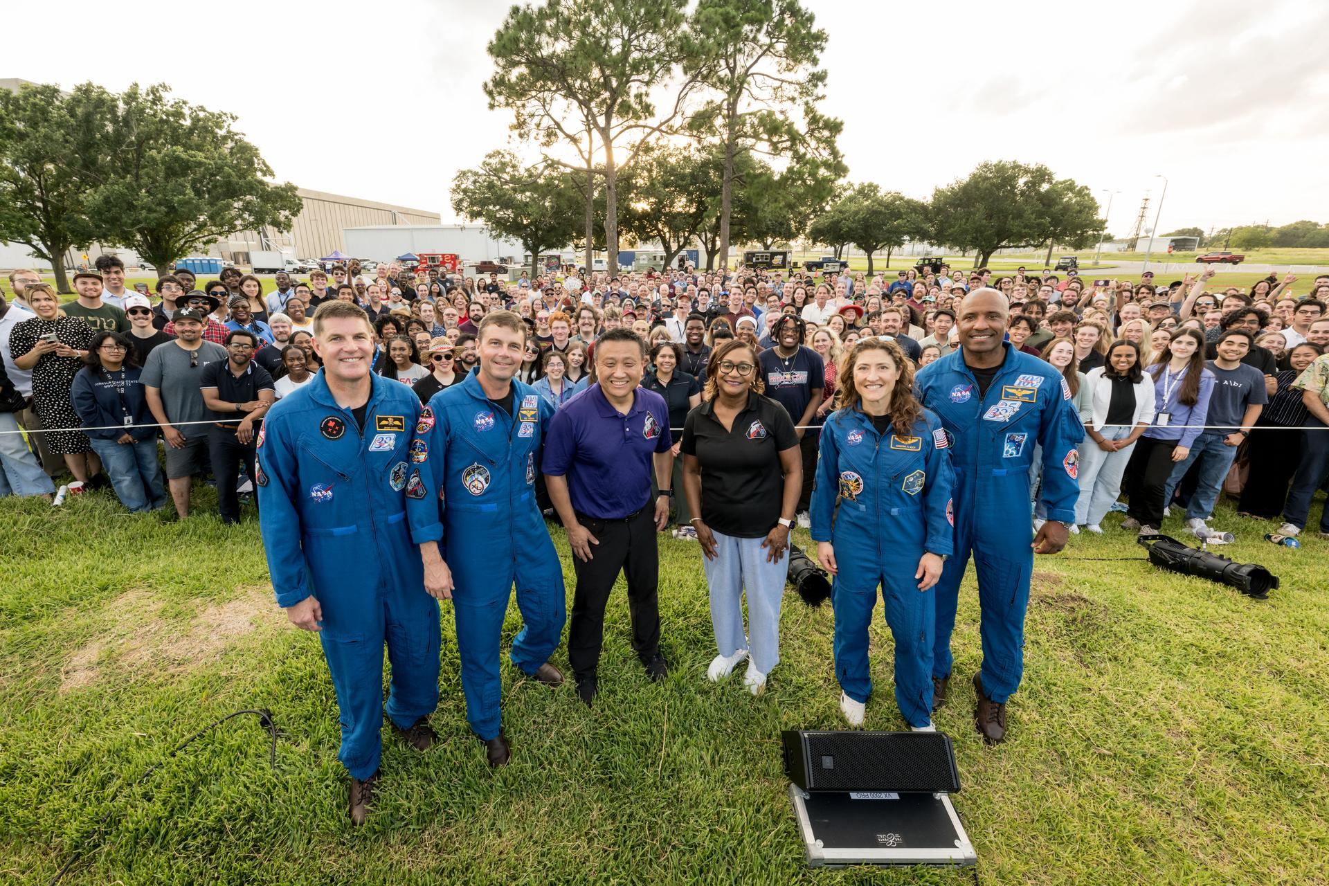 jsc2026e396705 (June 25, 2026) - NASA’s Artemis II crew, NASA astronauts Reid Wiseman, commander; Victor Glover, pilot; Christina Koch, mission specialist; and CSA (Canadian Space Agency) astronaut Jeremy Hansen, along with NASA's Johnson Space Center Director Vanessa Wyche and Orion Program Manager Howard Hu pose with employees at an Artemis II employee celebration event at NASA's Johnson Space Center. Credit: NASA