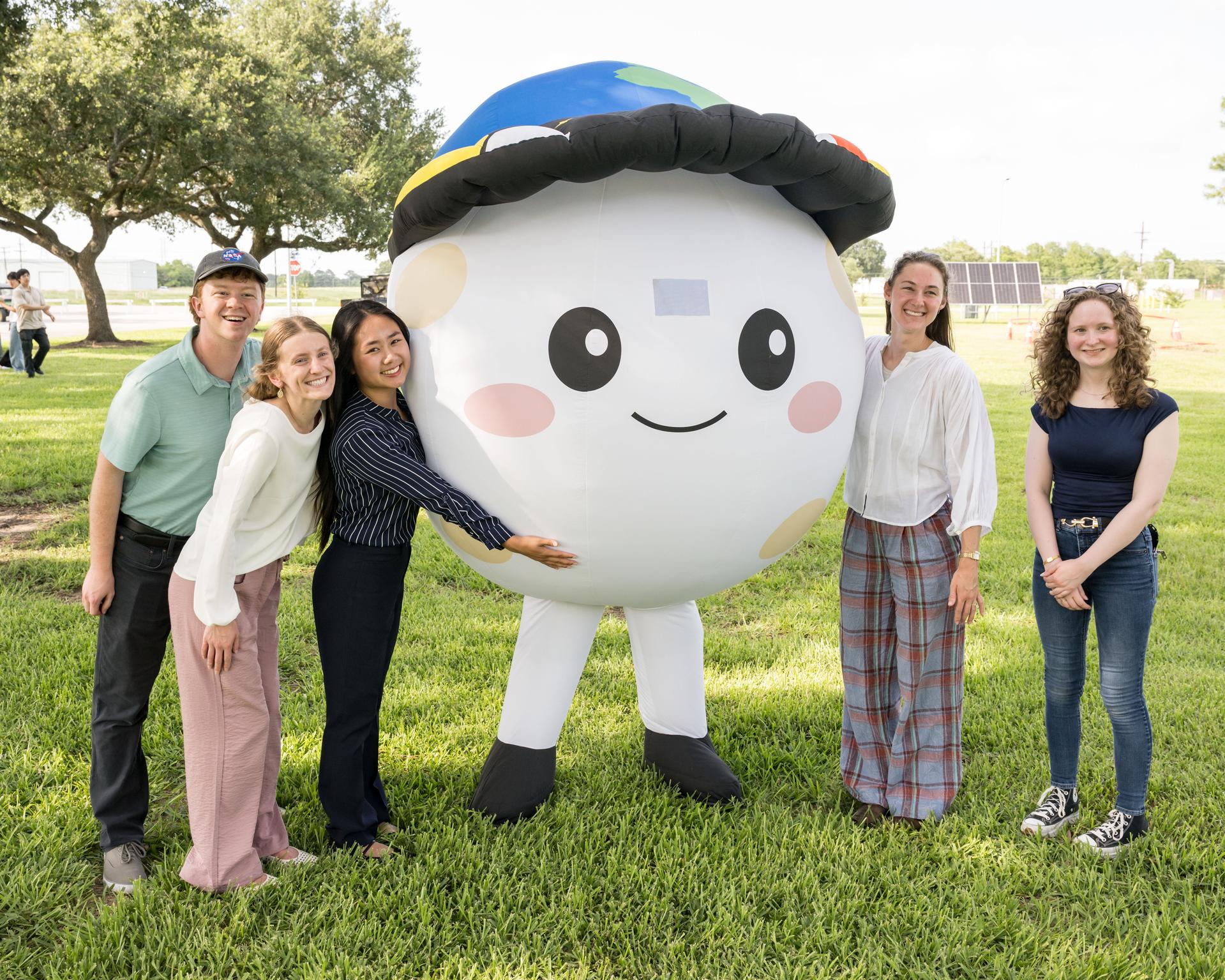 jsc2026e396712 (June 25, 2026) - Attendees pose with Rise, a representation of the zero gravity indicator of the Artemis II mission, during an Artemis II employee celebration event at NASA's Johnson Space Center. Credit: NASA