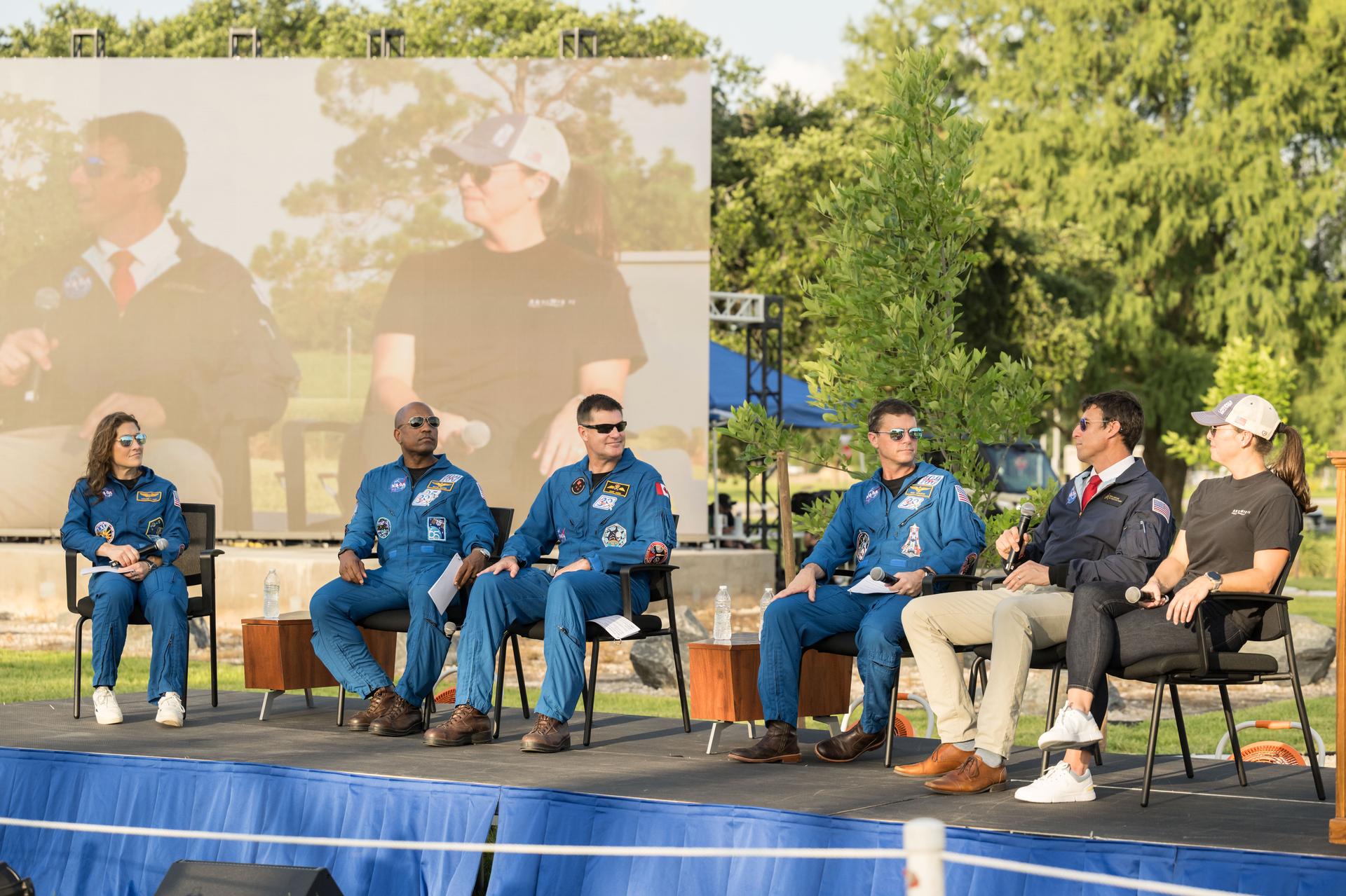 jsc2026e396781 (June 25, 2026) - Rick Henfling, Flight Director, and Branelle Rodriguez, Artemis II Orion Vehicle Manager, answer questions from the Artemis II crew during an Artemis II employee celebration event at the Lunar Receiving Park at NASA's Johnson Space Center. Credit: NASA