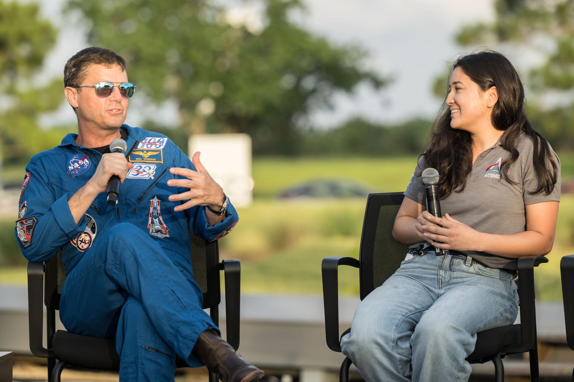 jsc2026e396785 (June 25, 2026) - NASA astronaut Reid Wiseman asks questions of Angela Garcia, Artemis II Science Officer, during an Artemis II employee celebration event at NASA's Johnson Space Center. Credit: NASA