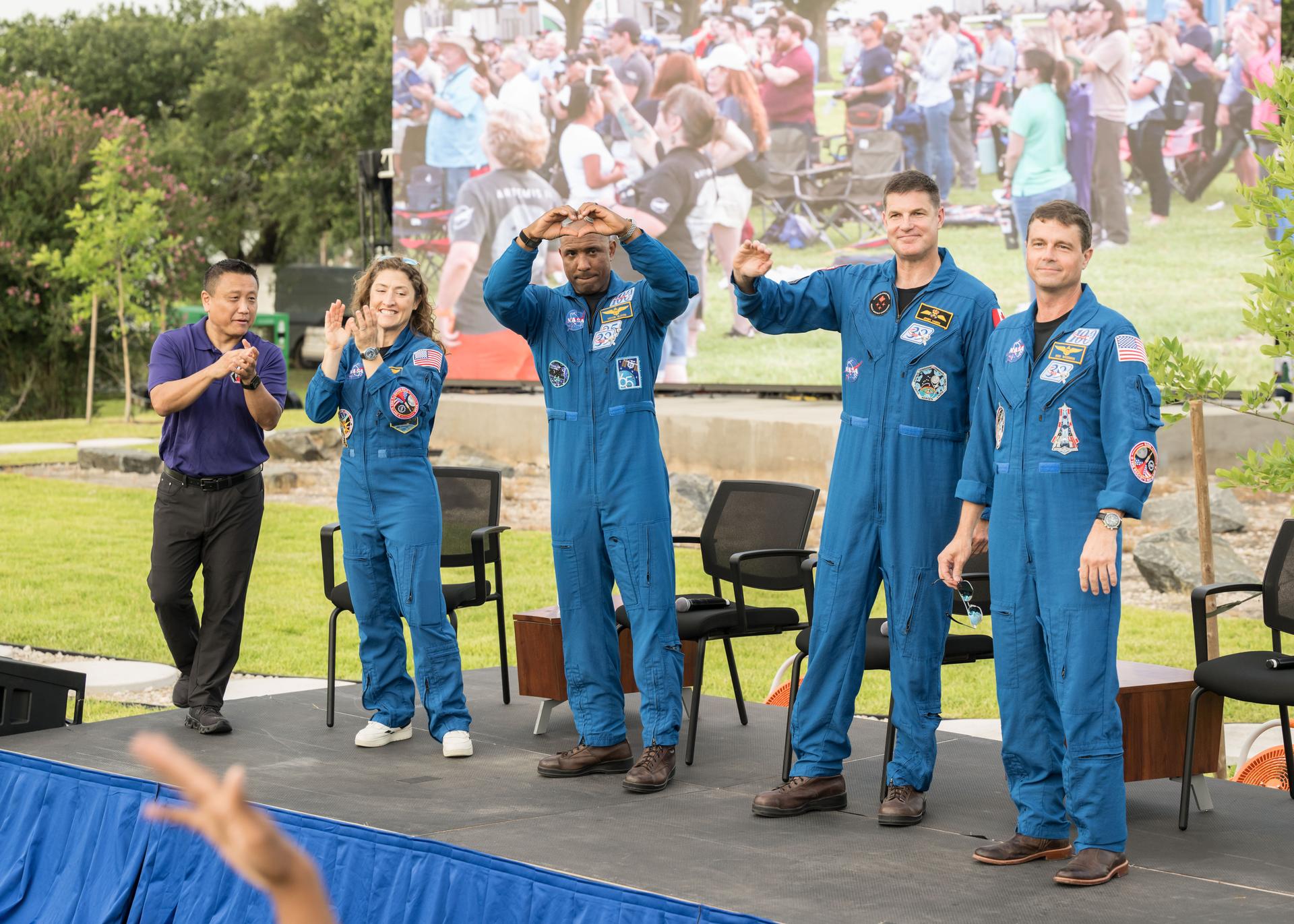 jsc2026e396790 (June 25, 2026) - NASA’s Artemis II crew address the crowd alongside Howard Hu, Orion Program Manager, at an Artemis II employee celebration event at the Lunar Receiving Park at NASA's Johnson Space Center. Credit: NASA