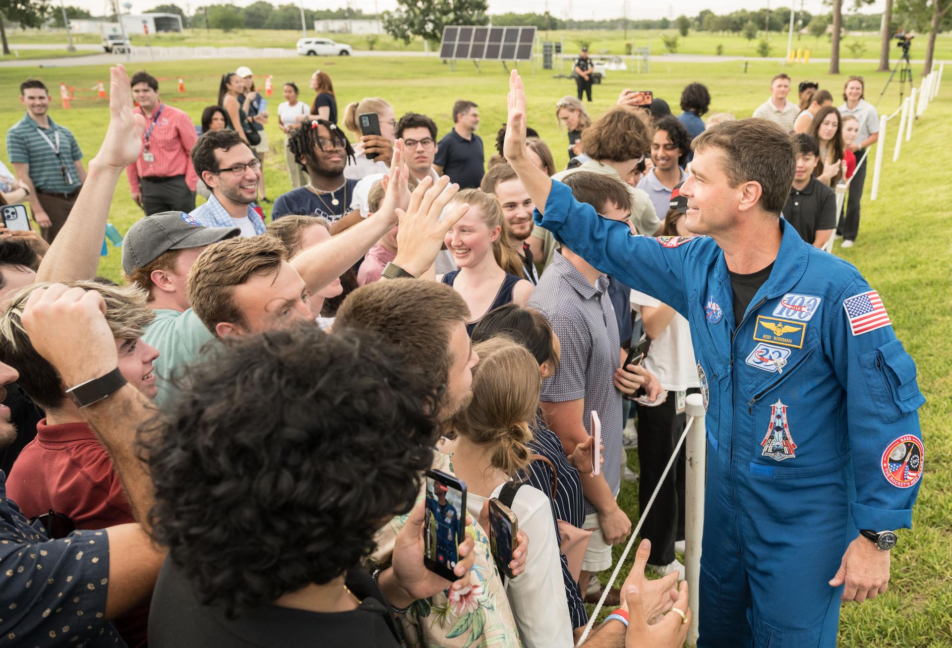 jsc2026e396793 (June 25, 2026) - NASA astronaut Reid Wiseman high-fives attendees at an Artemis II employee celebration event at NASA's Johnson Space Center. Credit: NASA