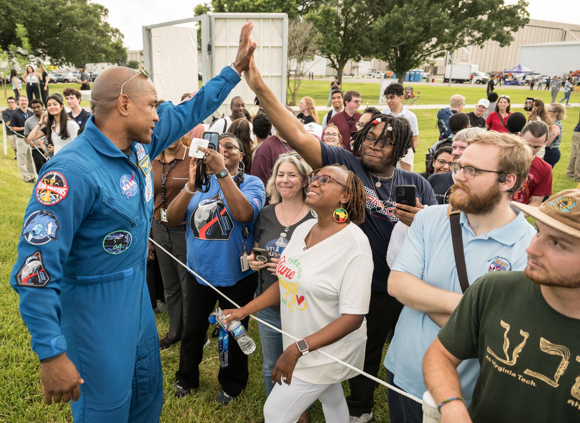 jsc2026e396795 (June 25, 2026) - NASA astronaut Victor Glover high-fives attendees at an Artemis II employee celebration event at NASA's Johnson Space Center. Credit: NASA