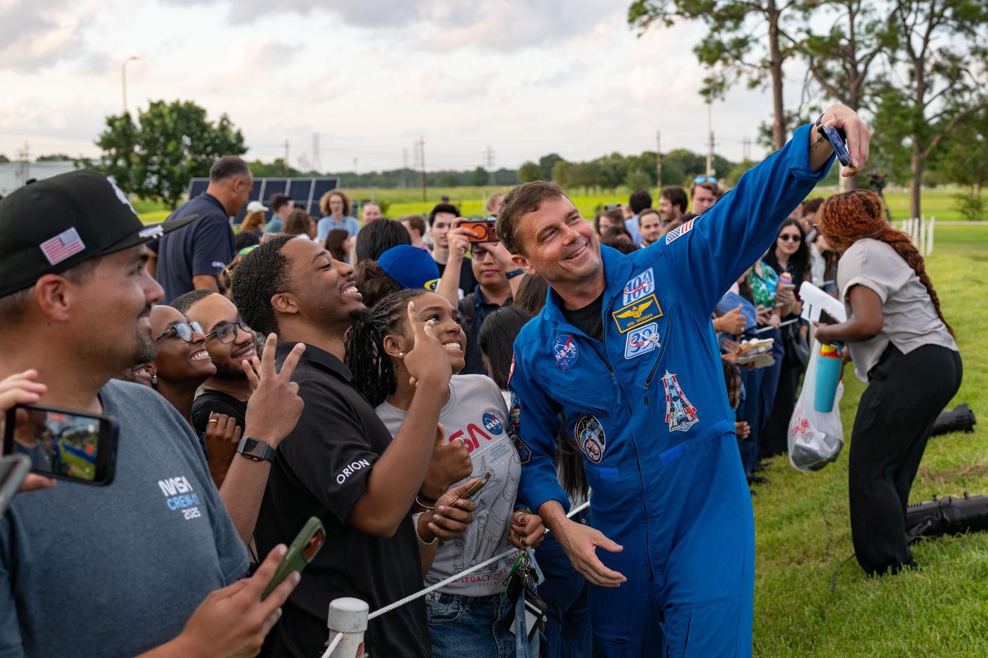 jsc2026e397516 (June 25, 2026) - NASA astronaut Reid Wiseman takes a selfie with attendees at an Artemis II employee celebration event at NASA's Johnson Space Center. Credit: NASA
