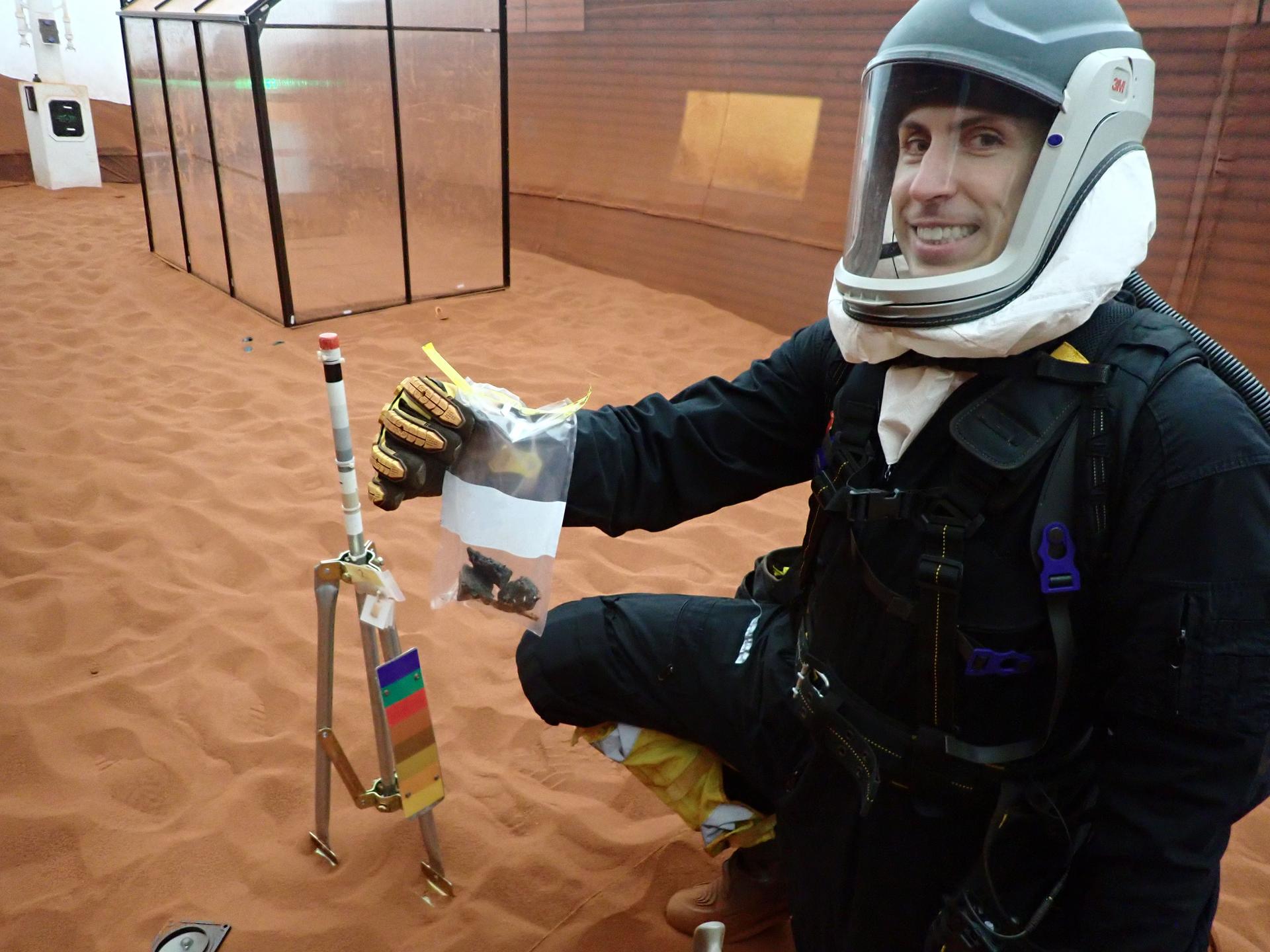 jsc2026e403172 (March 26, 2026) -- CHAPEA Mission 2 commander, Ross Elder, shows geological samples collected during a simulated extravehicular activity. Credit: NASA