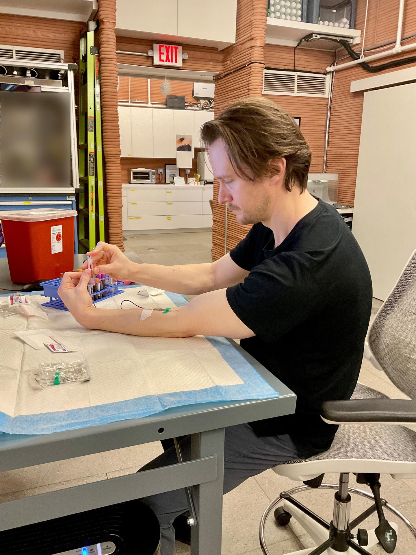 jsc2026e403178 (May 20, 2026) -- Matthew Montgomery, Crew Health and Performance Exploration Analog (CHAPEA) Mission 2 science officer, performing blood collection to monitor crew health. Credit: NASA