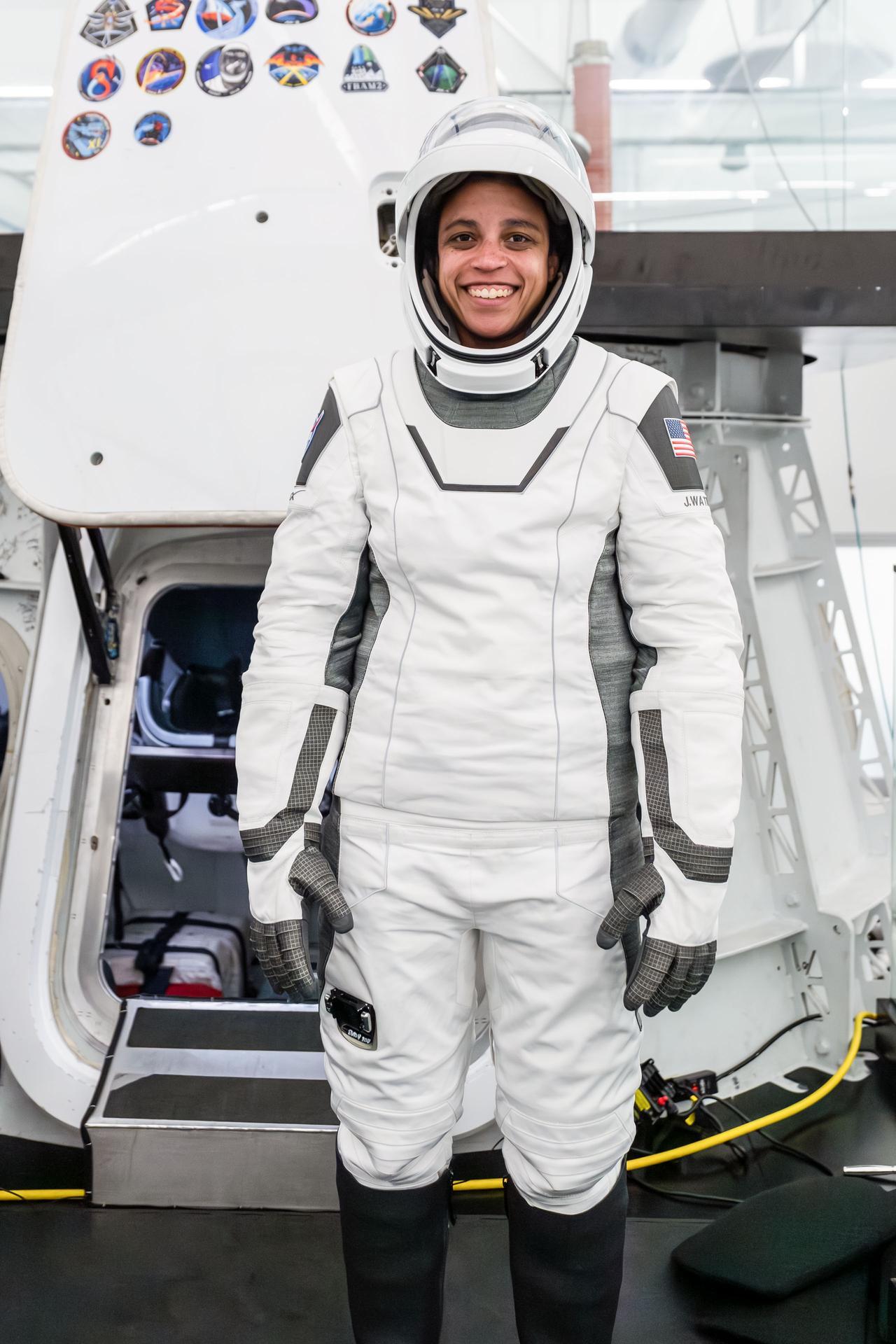 NASA astronaut and SpaceX Crew-13 Commander Jessica Watkins poses in her pressure suit in front of a Dragon spacecraft mockup during a pre-flight training session at SpaceX headquarters in Hawthorne, California.