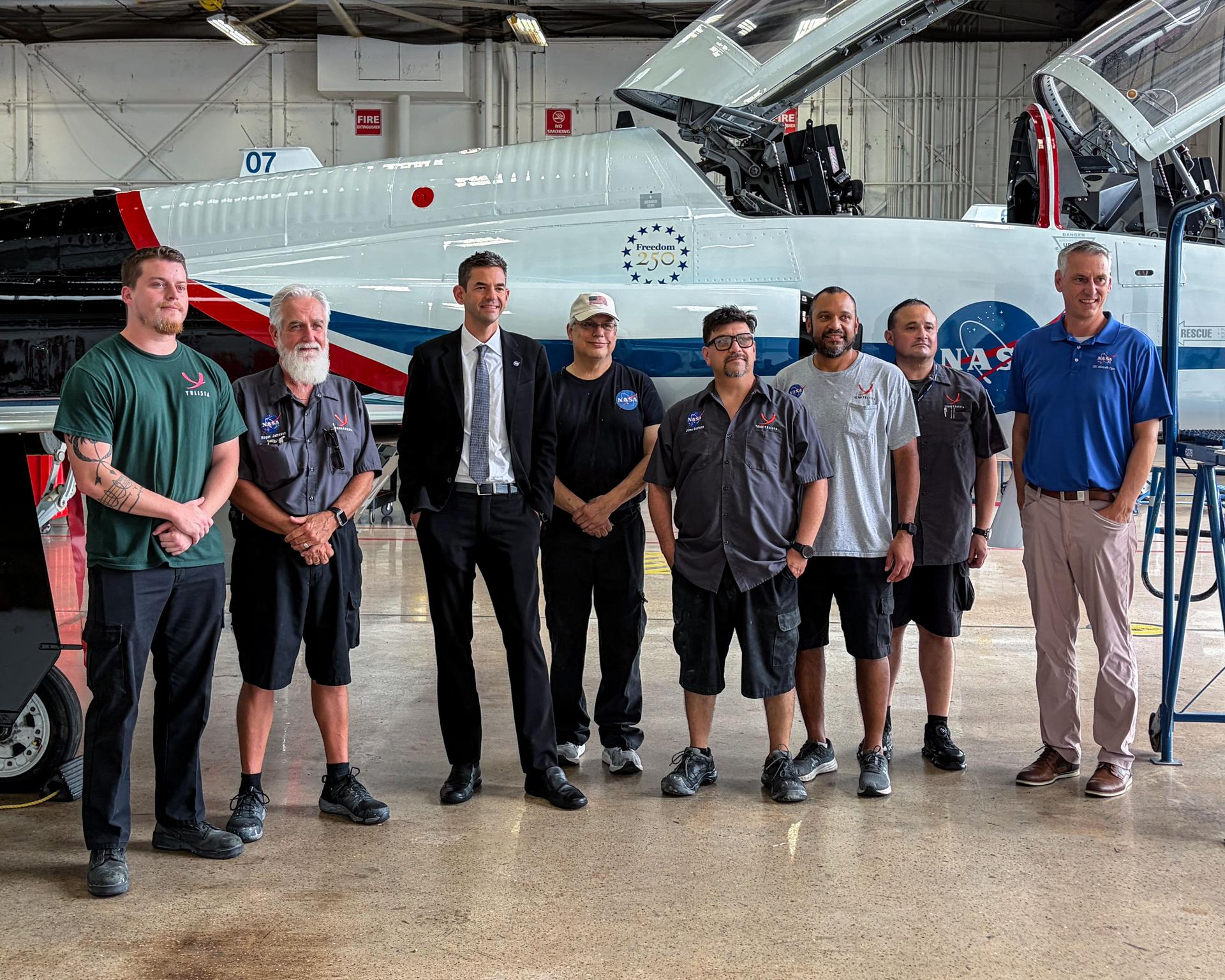 jsc2026e407799 (Aug. 6, 2026) - NASA administrator Jared Isaacman visited Ellington Field to admire the T-38 jet featuring a new paint job reflecting the Artemis Program. He met with the team members who designed and painted the aircraft, which NASA astronauts use to train for making real-time decisions in a high-stakes, operational environment.   Credit: NASA/James Blair