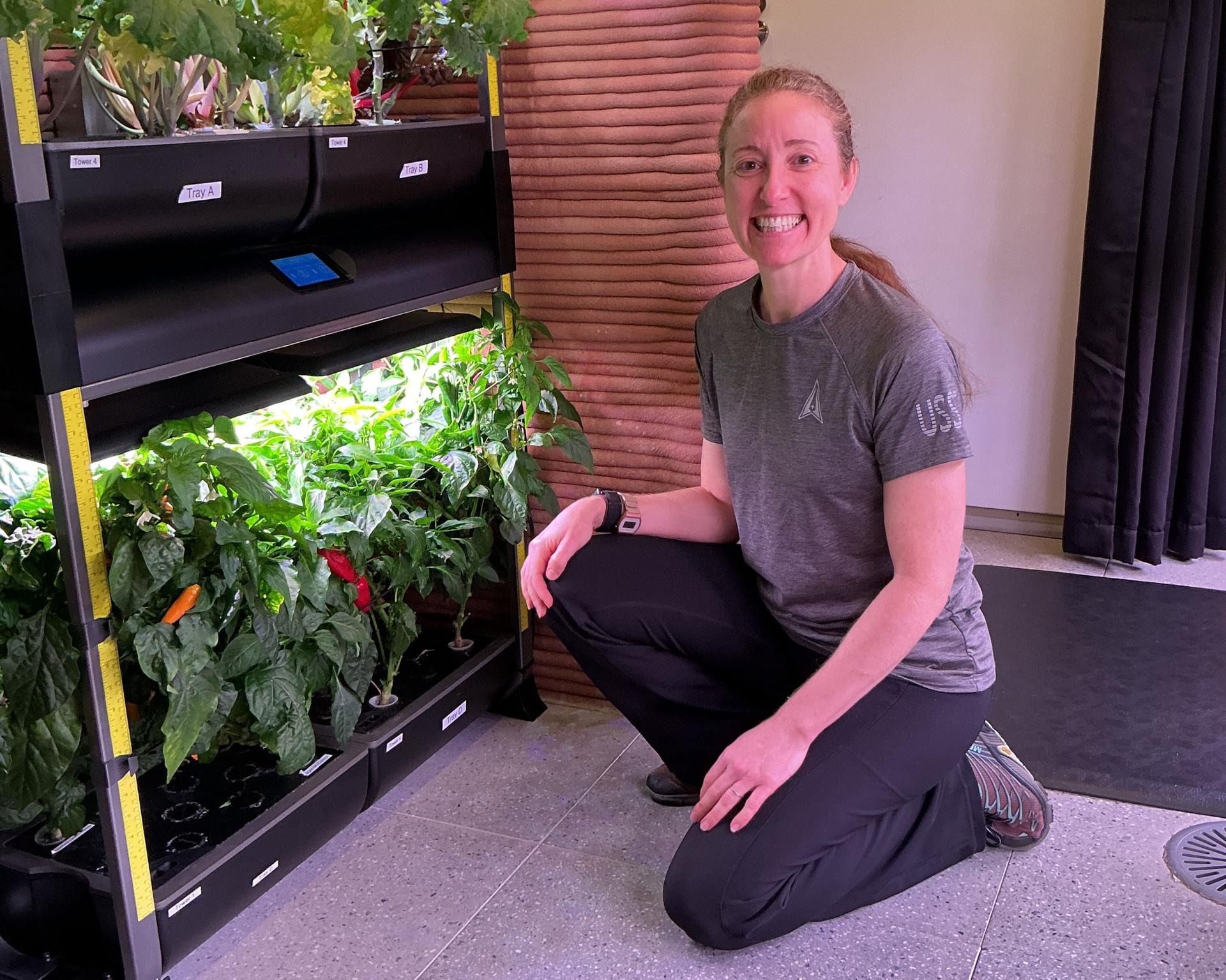 jsc2026e409148 (June 27, 2026) -- Crew Health and Performance Exploration Analog (CHAPEA) Mission 2 medical officer, Ellen Ellis, kneels in front of the hydroponic growth system. Credit: NASA