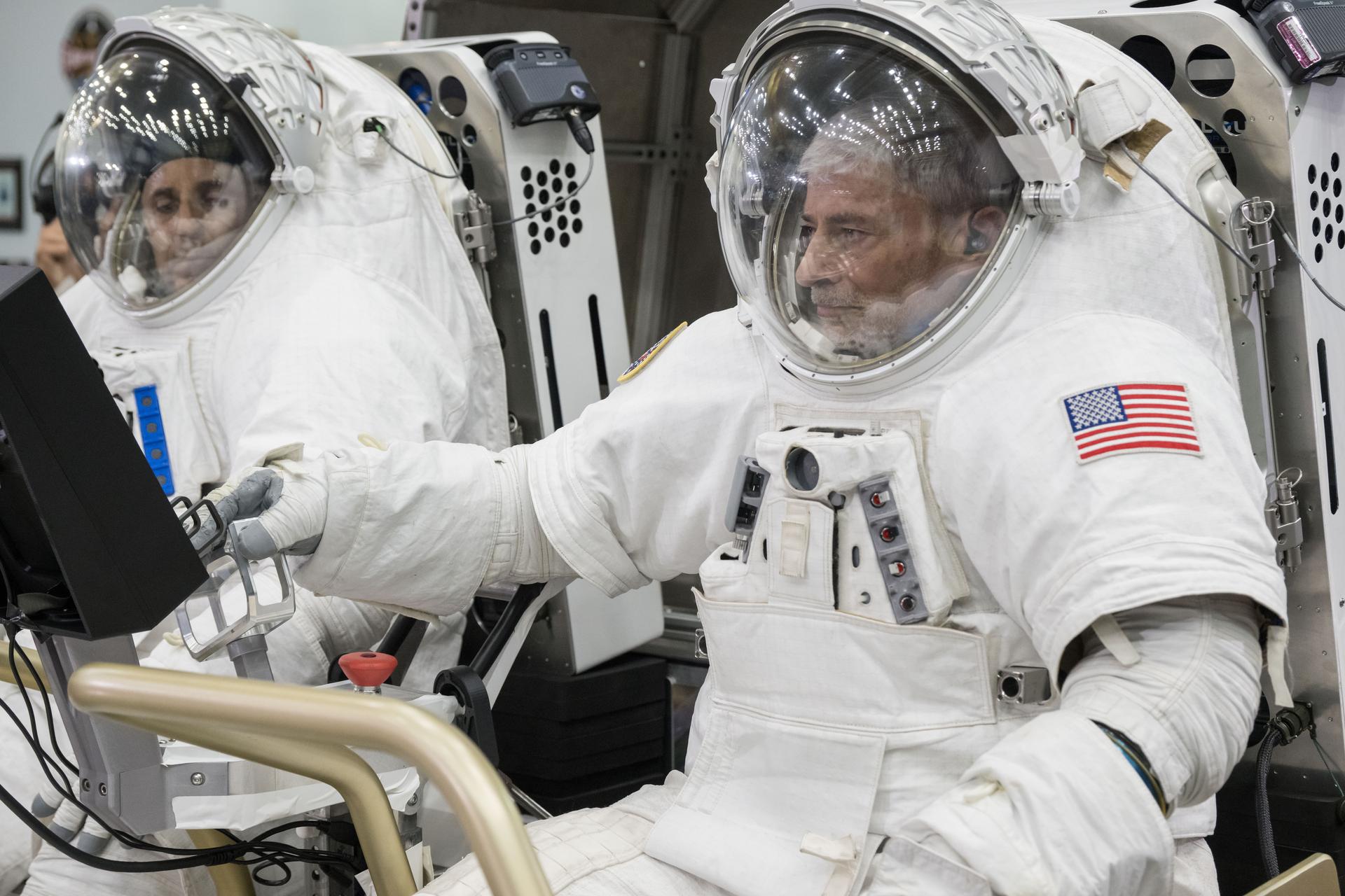NASA astronauts Joe Acaba (left) and Mark Vande Hei (right) sit inside Lunar Outpost’s Pegasus lunar terrain vehicle prototype during human-in-the-loop testing at NASA’s Johnson Space Center where they evaluated the design, usability, and crew comfort of Lunar Outpost’s lunar rover. NASA selected Lunar Outpost and Astrolab in May 2026 to build and deliver the first phase of lunar terrain vehicles for Moon Base development. Image Credit: NASA/Bill Stafford