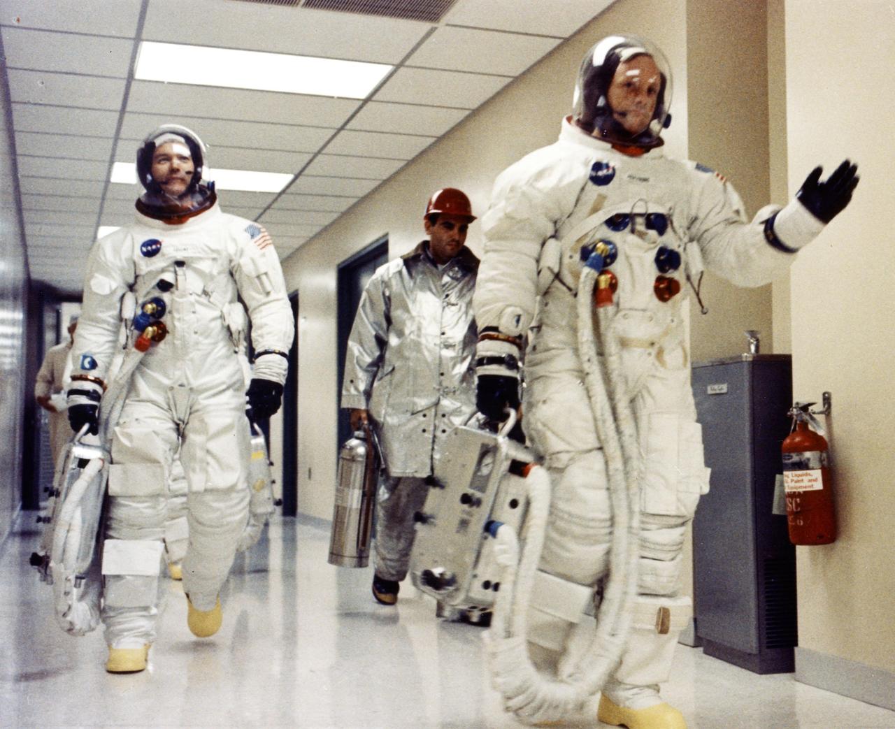 KENNEDY SPACE CENTER, FLA. --  Apollo 11 Commander Neil A. Armstrong waves to well-wishers in the hallway of the Manned Spacecraft Operations Building as he and Michael Collins and Edwin E. Aldrin Jr. prepare to be transported to Launch Complex 39A for the first manned lunar landing mission