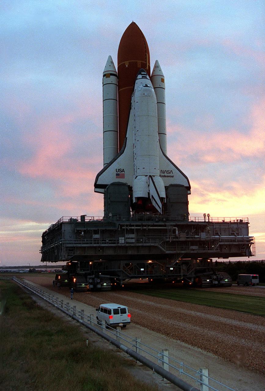 KENNEDY SPACE CENTER, FLA. -- A morning sky drenched in vibrant color welcomes the Space Shuttle Endeavour as it rolls out to Launch Pad 39A today. Endeavour is being readied for the STS-61 mission, targeted for liftoff in early December. During the 11-day flight, a seven-member crew will carry out the first servicing of the Hubble Space Telescope