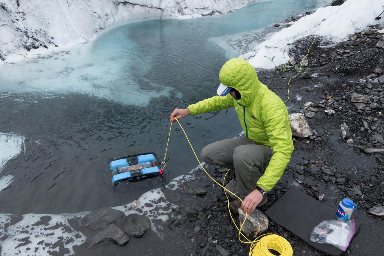 JPL engineer Andy Klesh lowers a robotic submersible into a moulin. Klesh and JPL's John Leichty used robots and probes to explore the Matanuska Glacier in Alaska this past July. Image Credit: NASA/JPL-Caltech