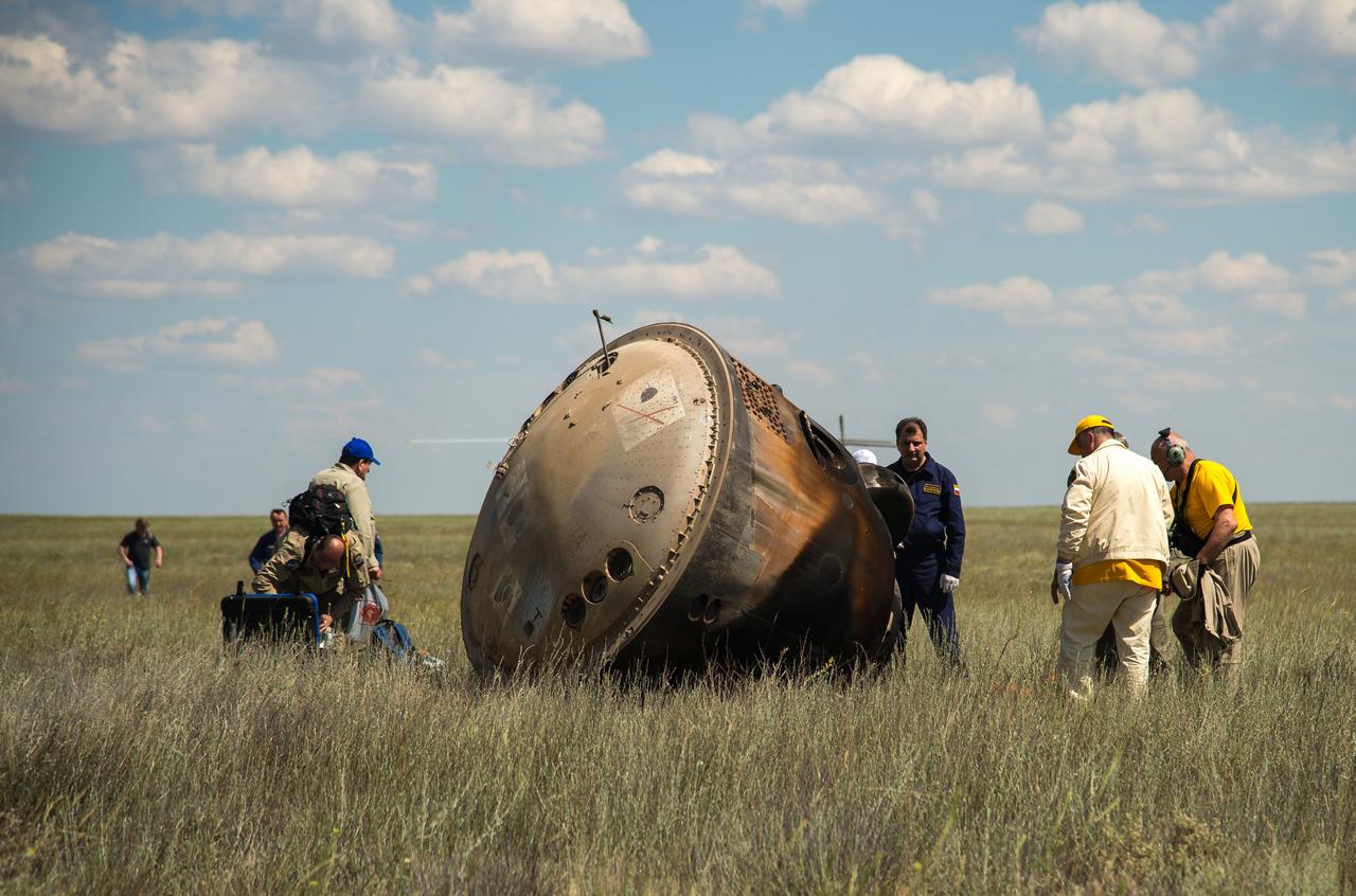 Russian support personnel work around the Soyuz TMA-19M spacecraft after it landed with Expedition 47 crew members Tim Kopra of NASA, Tim Peake of the European Space Agency, and Yuri Malenchenko of Roscosmos near the town of Zhezkazgan, Kazakhstan on Saturday, June 18, 2016. Kopra, Peake, and Malenchenko are returning after six months in space where they served as members of the Expedition 46 and 47 crews onboard the International Space Station. Photo Credit: (NASA/Bill Ingalls)
