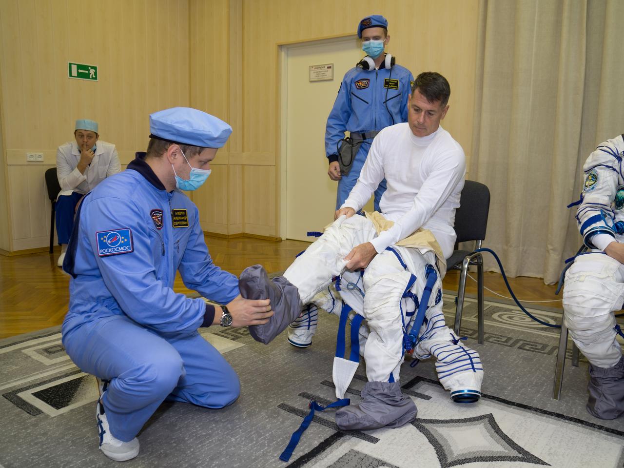 Expedition 49 flight engineer Shane Kimbrough is helped into his Sokol launch and entry suit in preparation for conducting the first check dress rehearsal activities, Saturday, Oct. 8, 2016 at the Baikonur Cosmodrome in Kazakhstan. Kimbrough, Sergey Ryzhikov, and Andrey Borisenko of Roscosmos will launch from the Baikonur Cosmodrome in Kazakhstan on Oct. 19. Photo Credit: (NASA/Victor Zelentsov)