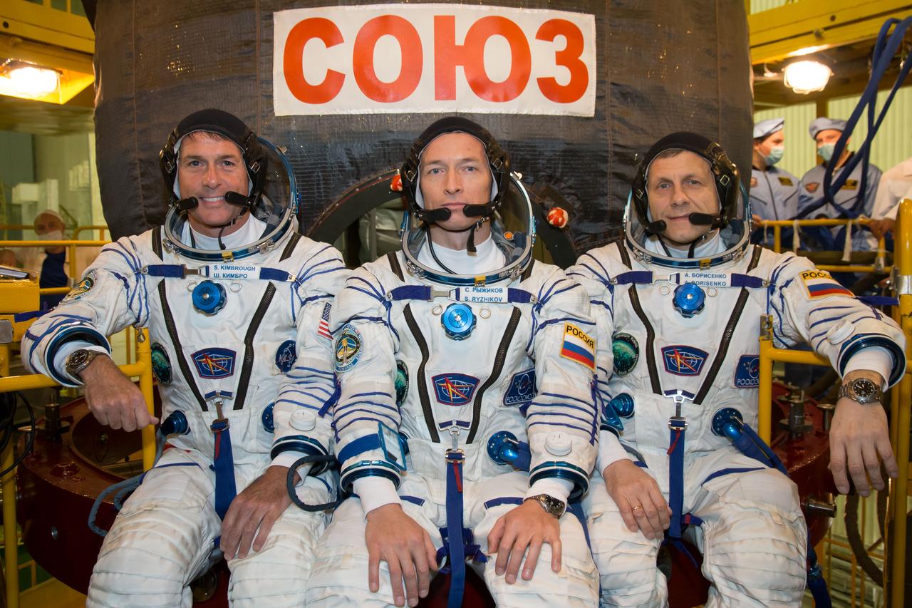 Expedition 49 flight engineer Shane Kimbrough of NASA, left, Soyuz commander Sergey Ryzhikov, center, and flight engineer Andrey Borisenko of Roscosmos, right, pose for pictures, in their Sokol launch and entry suits, in front of their Soyuz MS-02 spacecraft during their first check dress rehearsal activities, Saturday, Oct. 8, 2016 at the Baikonur Cosmodrome in Kazakhstan. Kimbrough, Ryzhikov, and Borsenko will launch from the Baikonur Cosmodrome in Kazakhstan on Oct. 19. Photo Credit: (NASA/Victor Zelentsov)