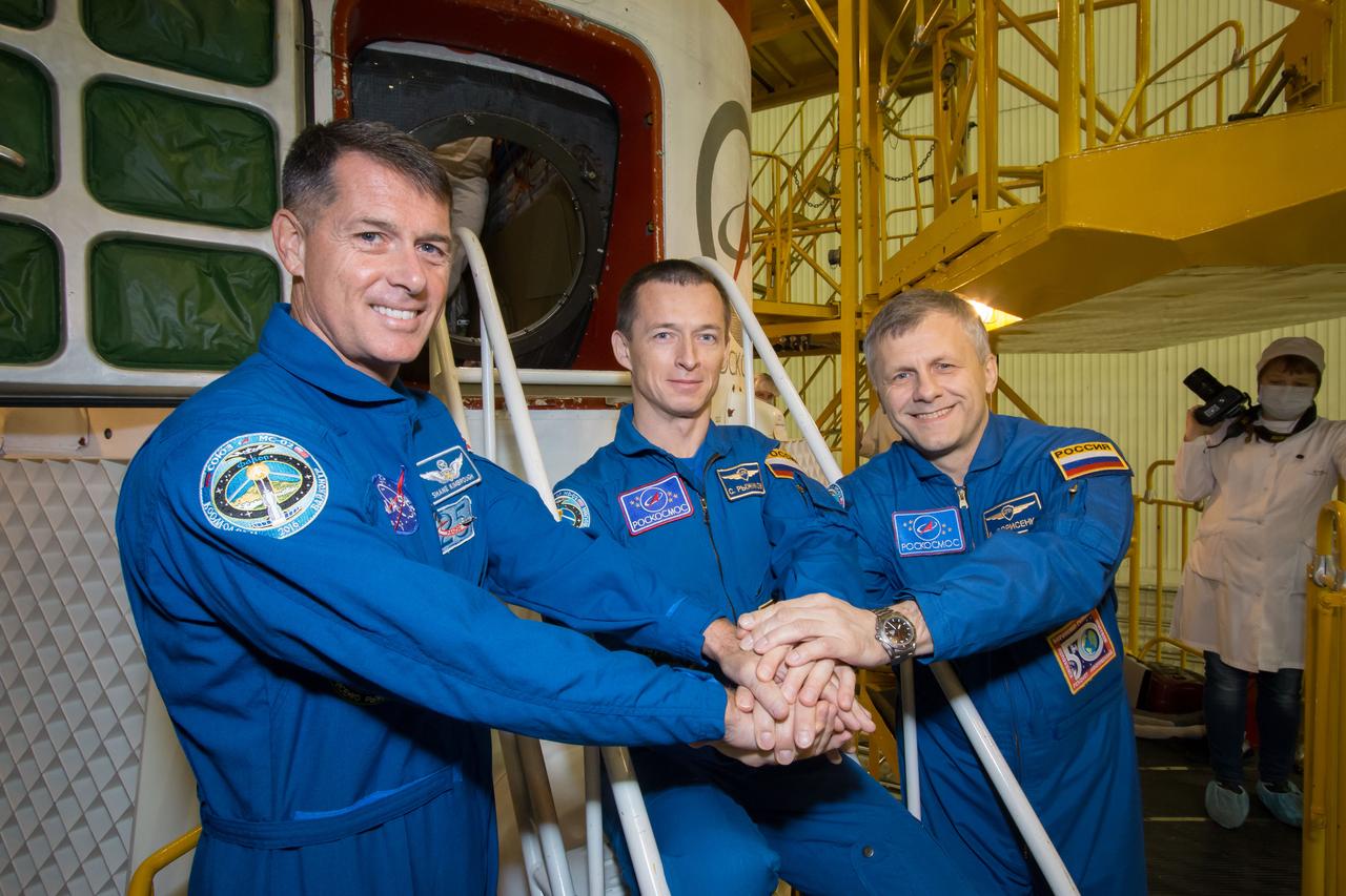 Expedition 49 flight engineer Shane Kimbrough of NASA, left, Soyuz commander Sergey Ryzhikov, center, and flight engineer Andrey Borisenko of Roscosmos, right, pose for pictures in front of their Soyuz MS-02 spacecraft during the final fit check of the spacecraft on Thursday, Oct. 13, 2016 at the Baikonur Cosmodrome in Kazakhstan. Kimbrough, Ryzhikov, and Borisenko are scheduled to launch from the Baikonur Cosmodrome in Kazakhstan on Oct. 19. Photo Credit: (NASA/Victor Zelentsov)