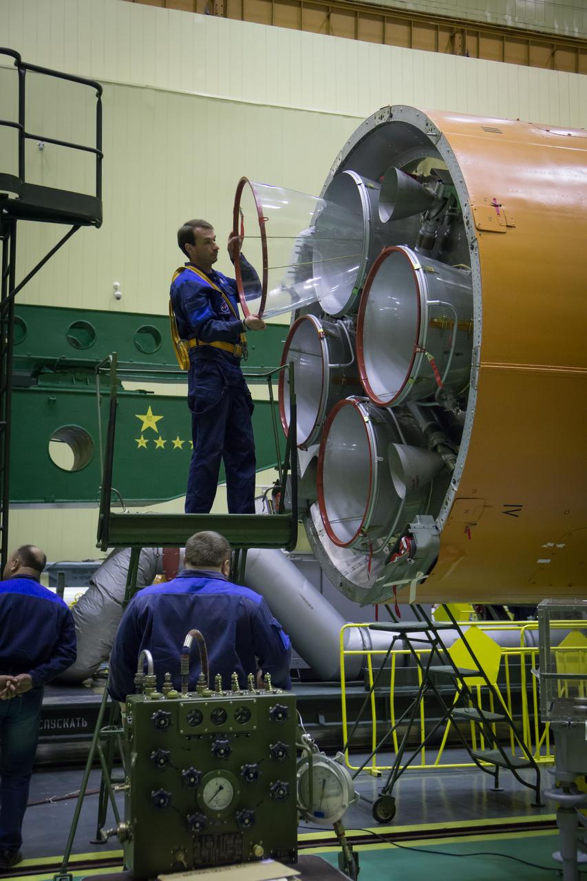 A worker removes a protective cover from an engine as the Soyuz rocket and Soyuz MS-02 spacecraft are assembled on Friday, Oct. 14, 2016 at the Baikonur Cosmodrome in Kazakhstan. Expedition 49 flight engineer Shane Kimbrough of NASA, Soyuz commander Sergey Ryzhikov of Roscosmos, and flight engineer Andrey Borisenko of Roscosmos are scheduled to launch from the Baikonur Cosmodrome in Kazakhstan on Oct. 19. Photo Credit: (NASA/Victor Zelentsov)