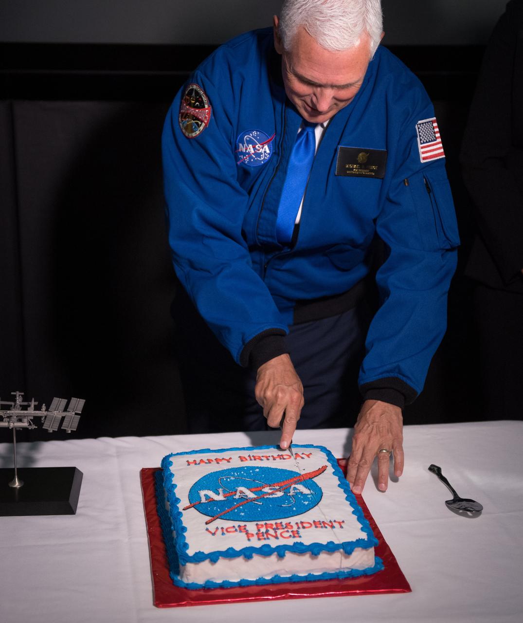 Vice President Mike Pence cuts a cake presented to him on his 58th birthday while touring the Christopher C. Kraft Jr. Mission Control Center, Wednesday, June 7, 2017 at NASA’s Johnson Space Center in Houston, Texas. The Vice President was at the space center to welcome  nhq201706070008 (06/07/2017) --- America’s newest astronaut candidates, chosen from more than 18,300 applicants to carry the torch for future human space exploration. After completing two years of training, the new astronaut candidates could be assigned to missions performing research on the International Space Station, launching from American soil on spacecraft built by commercial companies, and launching on deep space missions on NASA’s new Orion spacecraft and Space Launch System rocket. Photo Credit: (NASA/Bill Ingalls)
