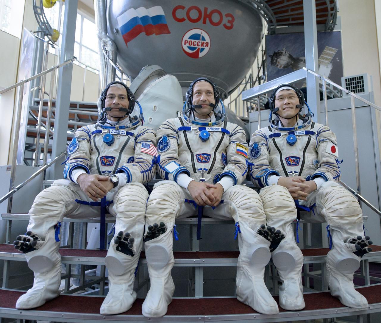 nhq2017070600103 (July 6, 2017) --- Expedition 52 backup crew members: Mark Vande Hei of NASA, left, Alexander Misurkin of Roscosmos, center, and Norishige Kanai of the Japan Aerospace Exploration Agency (JAXA) answer questions from the press outside the Soyuz simulator ahead of their Soyuz qualification exams, Thursday, July 6, 2017 at the Gagarin Cosmonaut Training Center (GCTC) in Star City, Russia. Photo Credit: (NASA/Bill Ingalls)