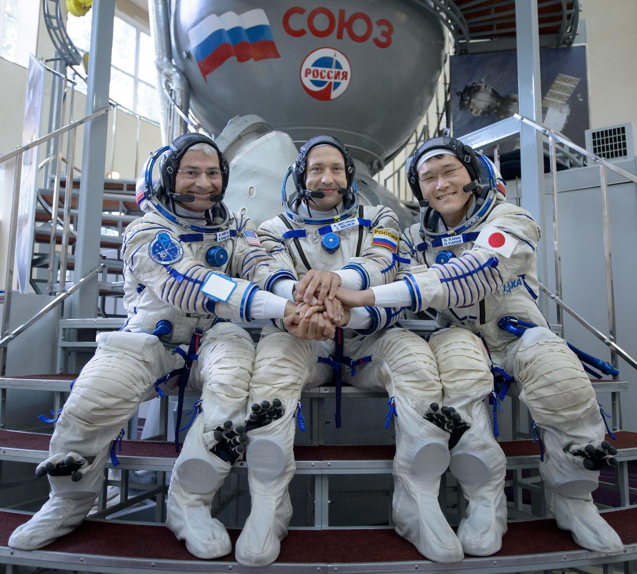 nhq2017070600104 (July 6, 2017) --- Expedition 52 backup crew members: Mark Vande Hei of NASA, left, Alexander Misurkin of Roscosmos, center, and Norishige Kanai of the Japan Aerospace Exploration Agency (JAXA) pose for a photograph outside the Soyuz simulator ahead of their Soyuz qualification exams, Thursday, July 6, 2017 at the Gagarin Cosmonaut Training Center (GCTC) in Star City, Russia. Photo Credit: (NASA/Bill Ingalls)