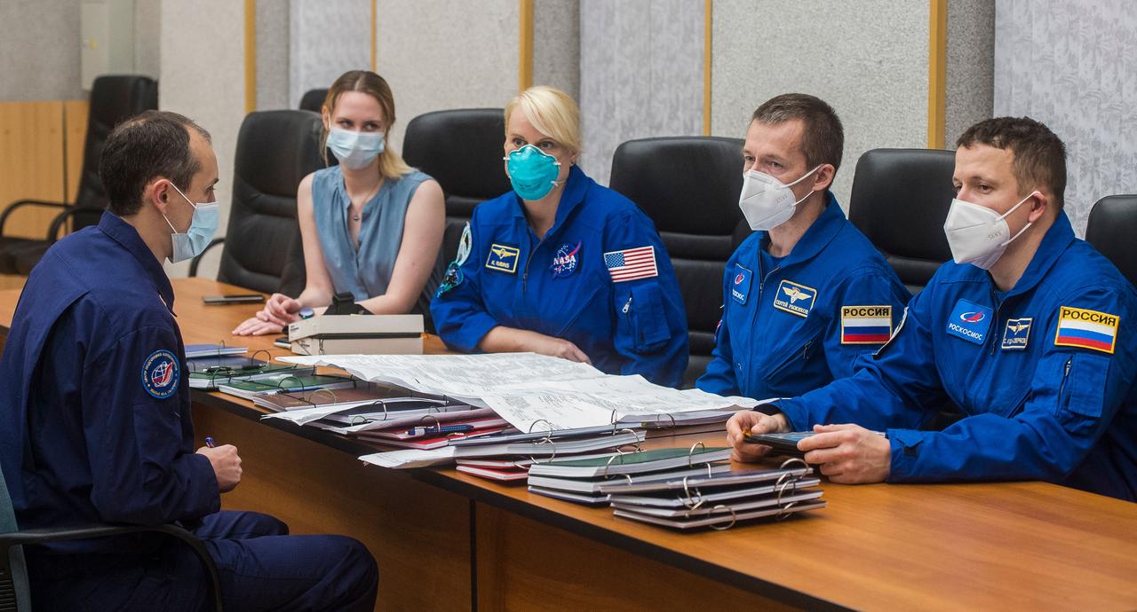 nhq202010060004 (Oct. 6, 2020) --- Expedition 64 crew members NASA astronaut Kate Rubins, left, and Russian cosmonauts Sergey Ryzhikov, center, and Sergey Kud-Sverchkov, right, of Roscosmos review launch procedures with trainers, Tuesday, Oct. 6, 2020, at the Cosmonaut Hotel in Baikonur, Kazakhstan. The trio are scheduled to launch to the International Space Station aboard the Soyuz MS-17 spacecraft on October 14. Photo Credit: (NASA/GCTC/Andrey Shelepin)