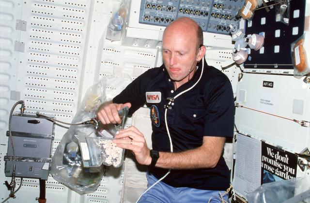 NASA image: Pilot Fullerton uses water dispenser kit gun to rehydrate food package