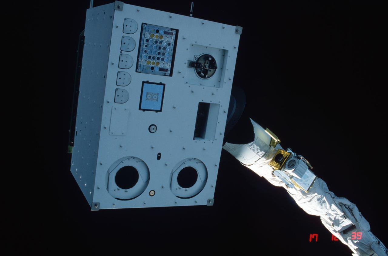 STS004-23-119 (27 June-4 July 1982) --- This is a close-up view of the Marshall Space Flight Center-developed Induced Environment Contamination Monitor (IECM), a multi-instrument box designed to check for contaminants in and around the space shuttle orbiter cargo bay which might adversely affect delicate experiments carried aboard. The astronaut crew of Thomas K. Mattingly II and Henry W. Hartsfield Jr. maneuvered the Canadian-built robot arm (called the remote manipulator system) very near their overhead flight deck windows and captured this scene with a 35mm camera. HOLD PICTURE HORIZONTALLY WITH FRAME NUMBER AT TOP CENTER. Cameras for the 11 instruments are pictured as black circles at the bottom of the frame. The access door to the arm and safe plug is located about halfway up the left edge of the box. A cascade injector device is immediately to the right of the plug. The rectangular opening at right center of the monitor is the optical effects module. Mass spectrometer is at upper left. Air sampler bottles are at upper left. The colorful rectangle near upper left of the monitor is the passive array. Not easily seen, but also a part of the instrument, are the cryogenic quartz crystal micro balance and the temperature controlled quartz micro balance. Photo credit: NASA