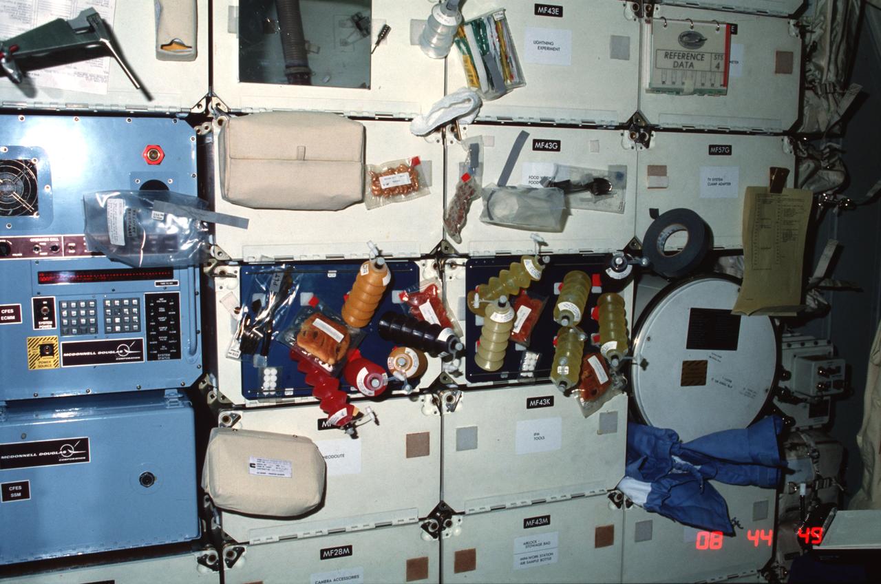 STS004-28-330 (27 June-4 July 1982) ---  Thanks to a variety of juices and other food items, this array in the middeck area probably represents the most colorful area onboard the Earth-orbiting space shuttle Columbia. Most of the meal items have been carefully fastened to food trays and locker doors (or both). What has not been attached by conventional methods has been safely ?tucked? under something heavy (note jacket shoved into space occupied by one of Columbia?s experiments). The Monodisperse Latex Reflector (MLR), making its second flight on Columbia, is designed to test the feasibility of making large-size, monodisperse (same size), and polystyrene latex micro-spheres using the products of the STS-3 mission as seed particles. The latex spheres are used in calibration of scientific and industrial equipment and have potential medical and research applications. This frame was exposed with a 35mm camera. Onboard the space vehicle for seven days were astronauts Thomas K. Mattingly II and Henry W. Hartsfield Jr. Photo credit: NASA