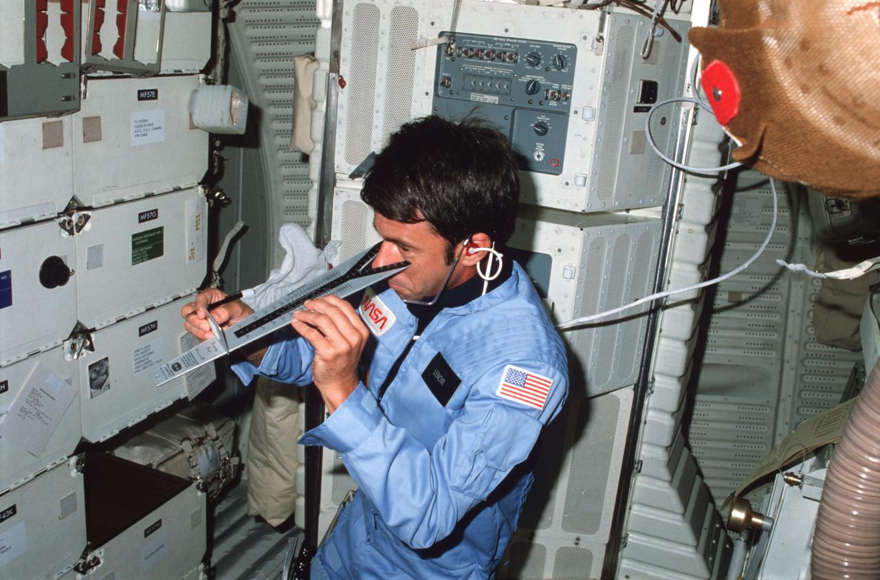 STS005-04-146 (11-16 Nov. 1982) --- Astronaut William B. Lenoir, STS-5 mission specialists, checks his vision using DIOPTER measuring device on middeck in front of Development Flight Instrument (DFI) unit. Photo credit: NASA
