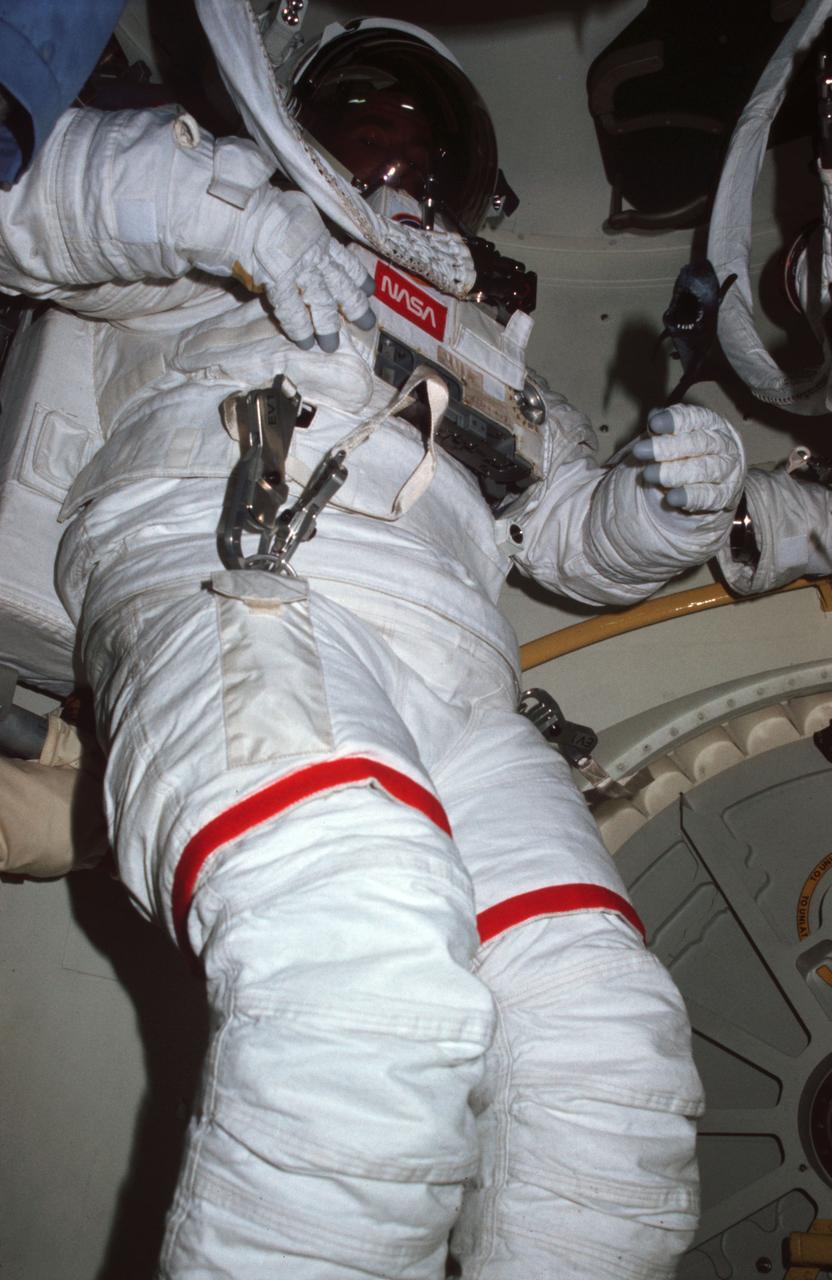 STS005-15-548 (11-16 Nov. 1982) --- Astronaut William B. Lenoir, STS-5 mission specialist, has donned the complete Extravehicular Mobility Unit (EMU) spacesuit in the airlock of the Earth-orbiting space shuttle Columbia. Dr. Lenoir and astronaut Joseph P. Allen IV, the flight?s other mission specialist, were to have participated in an extravehicular activity (EVA) today but problems with both EMU?s caused cancellation of the activity. The photograph was made by Dr. Allen using a 35mm camera. Photo credit: NASA