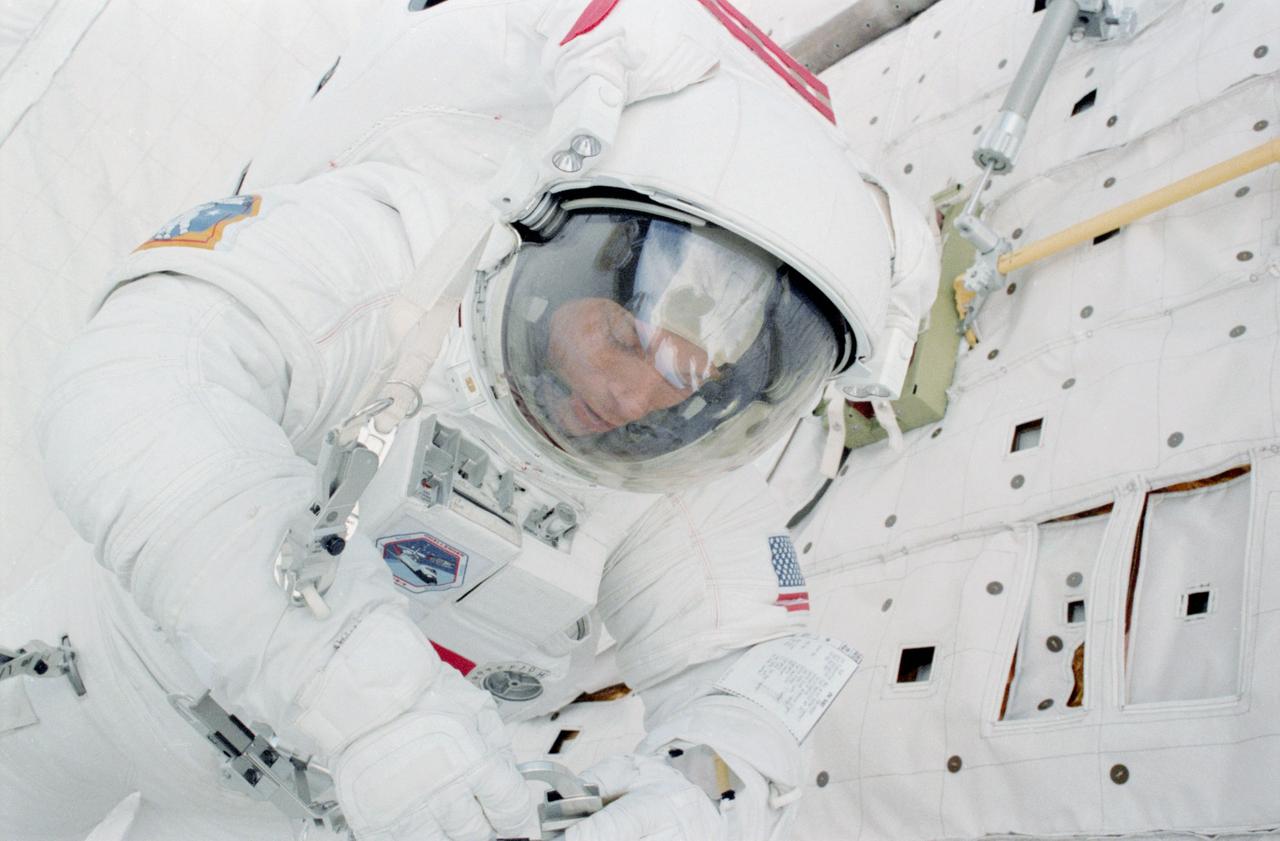 STS006-22-026 (7 April 1983) --- Astronaut F. Story Musgrave, one of two STS-6 mission specialists who performed a lengthy, successful extravehicular activity (EVA) in the cargo bay of the Earth orbiting space shuttle Challenger, anchors himself near the forward bulkhead of the reusable vehicle. Astronaut Donald H. Peterson, sharing the cargo bay with Dr. Musgrave, exposed this frame with a 35mm camera, while astronauts Paul J. Weitz, commander, and Karol J. Bobko, pilot, remained in the cabin. Photo credit: NASA