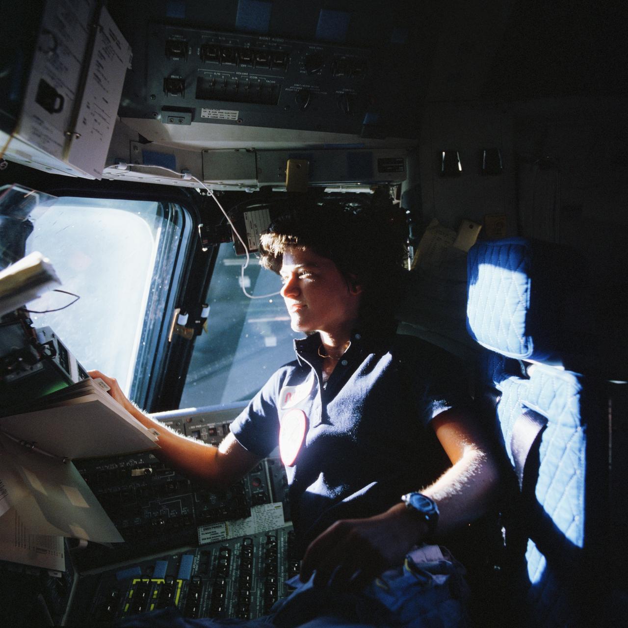 STS007-05-029 / S83-35783(5-13 Oct 1984) --- Astronaut Sally K. Ride, mission specialist, is shown here sitting in the front seat and looking out the windows of the Earth-orbiting Space Shuttle Challenger.  Ride and four other crew members are onboard the Challenger.