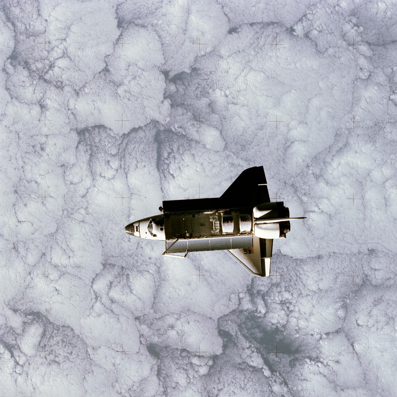 STS007-32-1667 (22 June 1983) --- The Earth-orbiting Space Shuttle Challenger over a heavily cloud-covered portion of the Earth was captured by a 70mm camera onboard the temporarily free-flying Shuttle Pallet Satellite (SPAS-01) during a busy Day 5 on the STS-7 mission. Visible in the cargo bay are the protective cradles for the now vacated Telesat Anik C2 and Palapa-B communications satellites, the pallet for the NASA Office of Space and Terrestrial Applications (OSTA-2); the Remote Manipulator System (RMS) and the KU-Band antenna. The STS-7 astronaut crew and the RMS arm later retrieved the SPAS and returned it to a stowed position in the cargo bay of the Space Shuttle Challenger for the return to Earth.