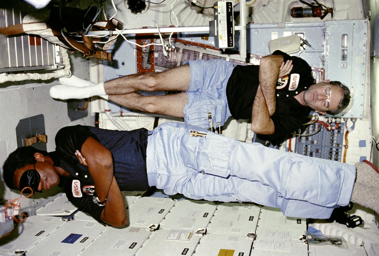 STS008-04-104 (13 Sept  1983) --- Richard H. Truly, crew commander; and Guion S. Bluford, mission specialist, merely fold their arms and stretch out for rest session.