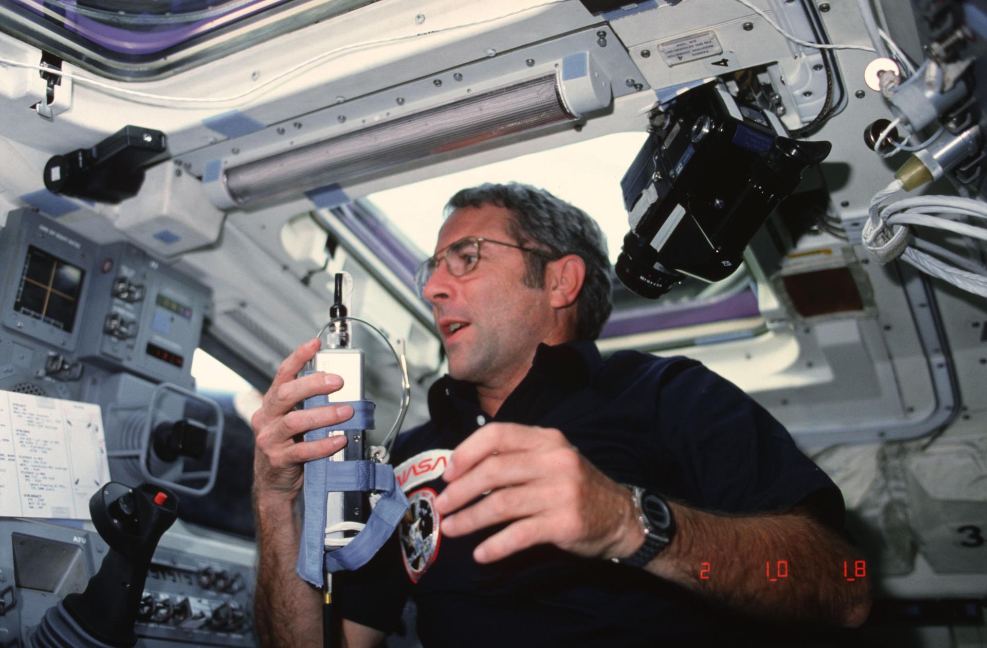 Richard M Truly is seen on the aft deck of Space Shuttle Challenger holding the communication kit assembly.