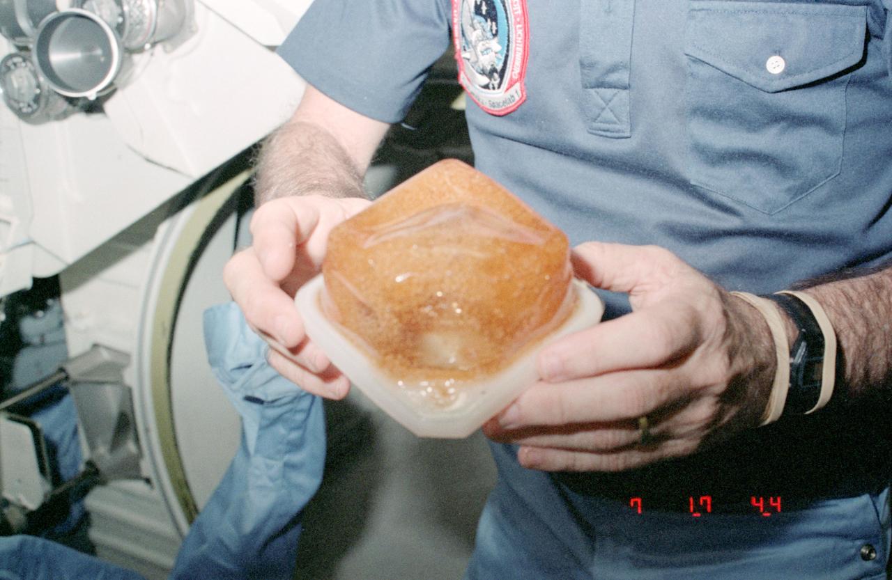 STS009-126-456 (28 Nov 1983) --- Water and coffee in beverage container during STS-9 flight. An extra amount of hydrogen in the H2O is believed to be the reason for the bubbling, distended effect in the container.
