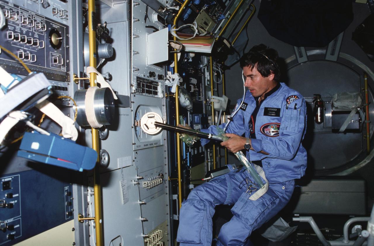 STS009-13-699 (28 Nov - 8 Dec 1983) --? Ulf Merbold, Spacelab 1 payload specialist, carries out one of the experiments using the gradient heating facility on the materials science double rack facility in the busy science module aboard the Earth-orbiting Space Shuttle Columbia.  Representing the European Space Agency, Dr. Merbold comes from Max-Planck Institute in Stuttgart, the Federal Republic of Germany.  He is a specialist in crystal lattice defects and low temperature physics.  The photograph was made with a 35mm camera.