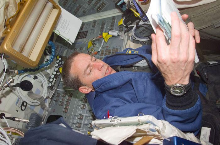 STS102-E-5012 (9 March 2001) --- Astronaut James D. Wetherbee, STS-102  mission commander, looks over a  procedures manual on the flight deck of  the Space Shuttle Discovery.  The commander and his crew are preparing for a series of very busy days ahead.  Once the Discovery links up with the International Space Station (ISS),  work on the orbiting outpost, crew personnel exchanges, supply transfers and a number of other chores face the astronauts and cosmonauts.