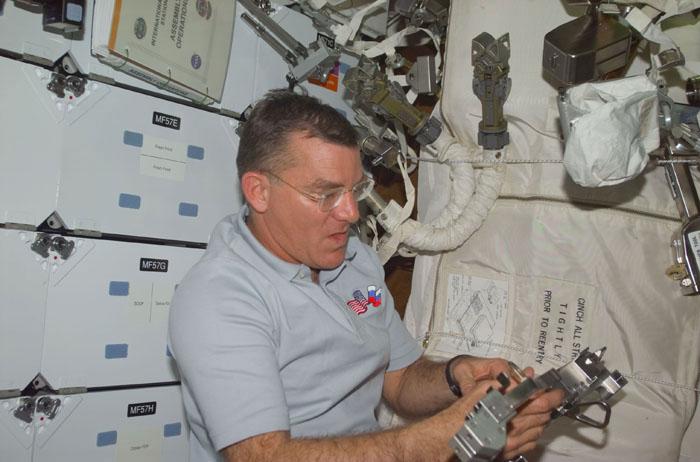 STS102-E-5030 (9 March 2001) --- Astronaut James S. Voss, mission specialist, scheduled for space walk duty in less than two days, looks over  gear on the mid deck of the Earth-orbiting Space Shuttle Discovery.