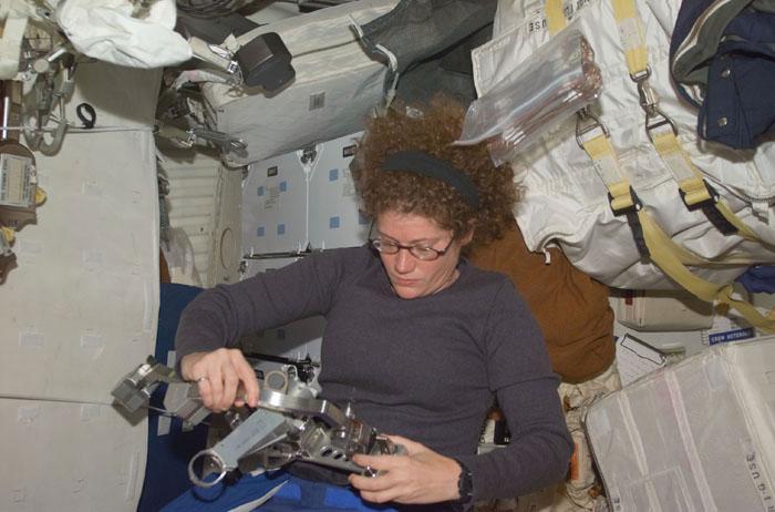 STS102-E-5031 (9 March 2001) --- On Discovery's mid deck, astronaut Susan J. Helms, STS-102 mission specialist, checks gear associated with her upcoming space walk.