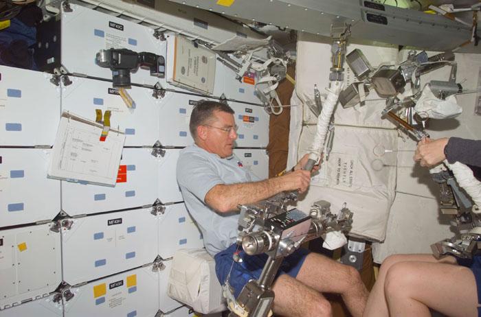 STS102-E-5032 (9 March 2001) --- On Discovery's mid deck, astronauts James S. Voss and Susan J. Helms (partially visible at right edge), STS-102 mission specialists, check gear associated with a scheduled space walk to perform work on the International Space Station (ISS). At the time this Flight Day 1 digital still camera image was exposed, the Discovery was on a time line to catch the orbital outpost and link with it during Flight Day 2.