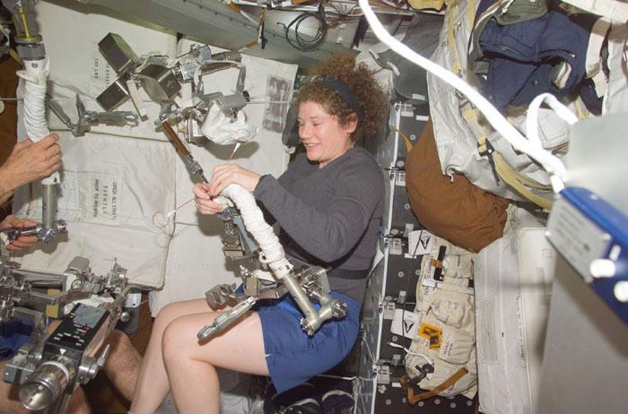 STS102-E-5033 (9 March 2001) --- On Discovery's mid deck, astronaut Susan J. Helms, STS-102 mission specialist, checks gear associated with her upcoming space walk.