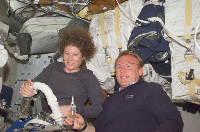 STS102-E-5034 (9 March 2001) --- Astronauts Susan J. Helms and Andrew S.W. Thomas, STS-102 mission specialists, check out some of the  extravehicular activity (EVA) gear  on Discovery's mid deck during Flight Day 1 activity.  Helms is scheduled to   participate in the space walk, less than two days away.