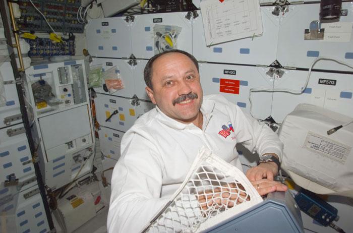 STS102-E-5039 (9 March 2001) --- Cosmonaut Yury V. Usachev, representing Rosaviakosmos, handles a locker's content on the mid deck of the Space Shuttle Discovery only hours away from assuming his role as a  full fledged International Space Station crew member. Usachev, Expedition Two commander, and two astronauts are scheduled to trade places with two cosmonauts and an astronaut who have been onboard the orbiting outpost since early November 2000.